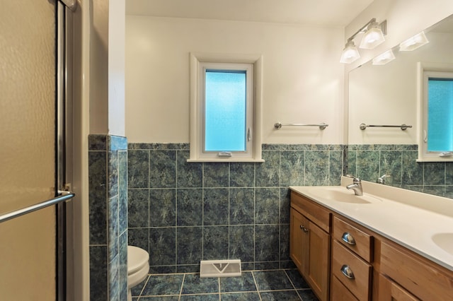 3010 Hill An Brook Dr, Portage, MI 49024 - full bath featuring tile walls, tile patterned floors, double vanity, wainscoting, and toilet