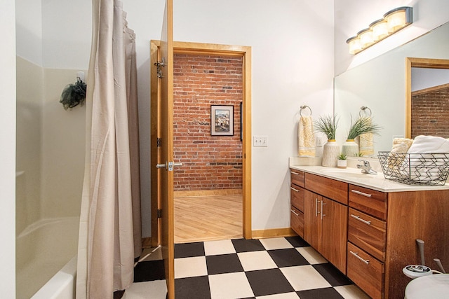 full bath with vanity, baseboards, brick wall, tile patterned floors, and shower / bath combination with curtain