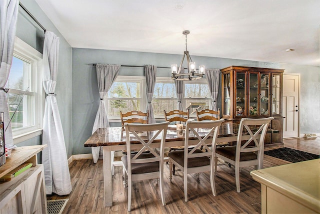 13627 Cadmus Rd, Hudson, MI 49247 - dining space with baseboards, wood finished floors, and a notable chandelier