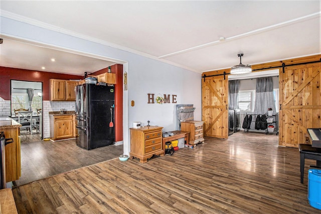 13627 Cadmus Rd, Hudson, MI 49247 - living area featuring a barn door, crown molding, dark wood-style floors, and plenty of natural light