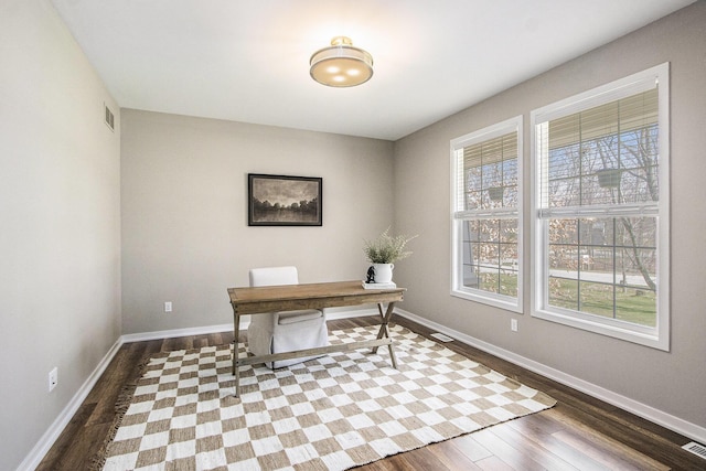 office space featuring dark wood-type flooring, baseboards, and visible vents