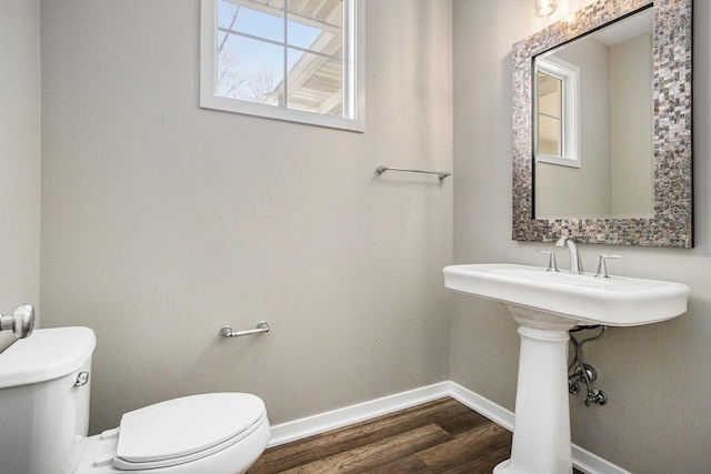 bathroom featuring toilet, wood finished floors, and baseboards