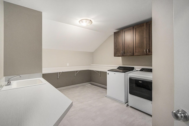 washroom with a sink, washing machine and clothes dryer, and cabinet space