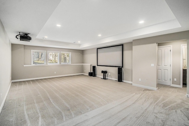 home theater room featuring a raised ceiling, light colored carpet, and recessed lighting