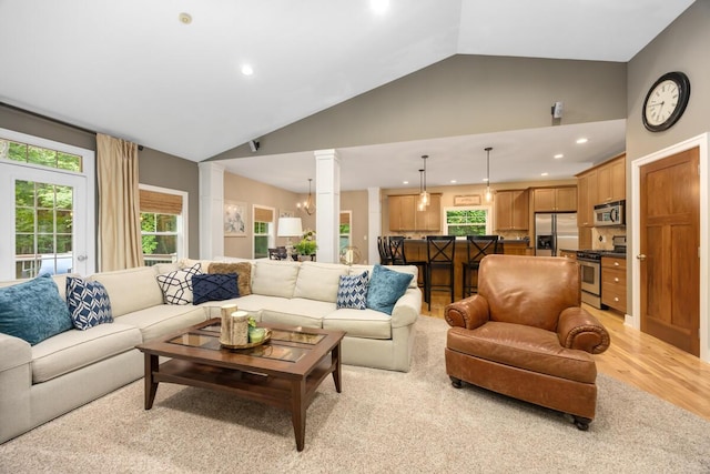 8702 E 98th St, Howard City, MI 49329 - living room featuring recessed lighting, light wood-style floors, ornate columns, and high vaulted ceiling