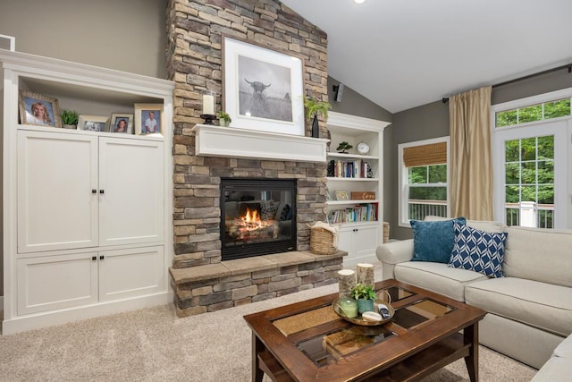 8702 E 98th St, Howard City, MI 49329 - living area featuring vaulted ceiling, a stone fireplace, carpet flooring, and built in features