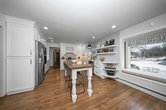 kitchen featuring open shelves, white cabinetry, stainless steel appliances, and a sink