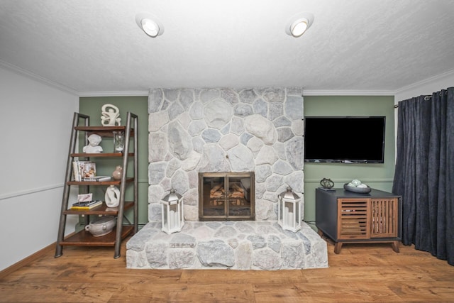 living room with crown molding, wood finished floors, and a fireplace