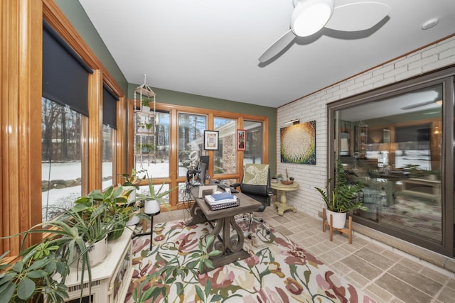 sunroom featuring brick wall and a healthy amount of sunlight