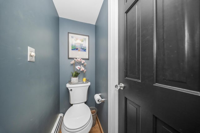 bathroom featuring a baseboard radiator, toilet, and baseboards