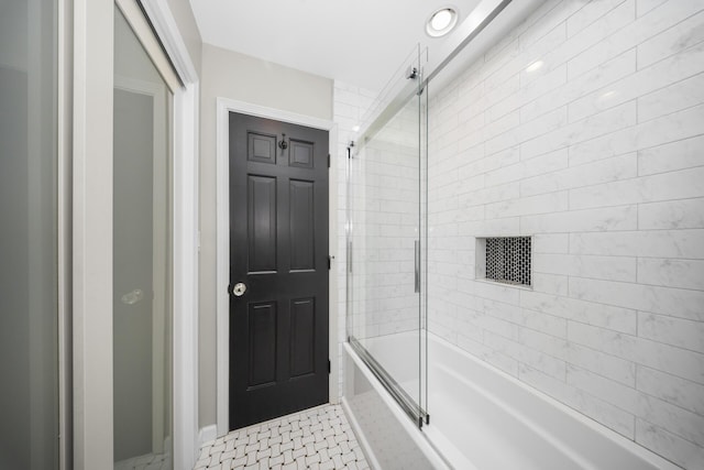 bathroom featuring enclosed tub / shower combo and baseboards