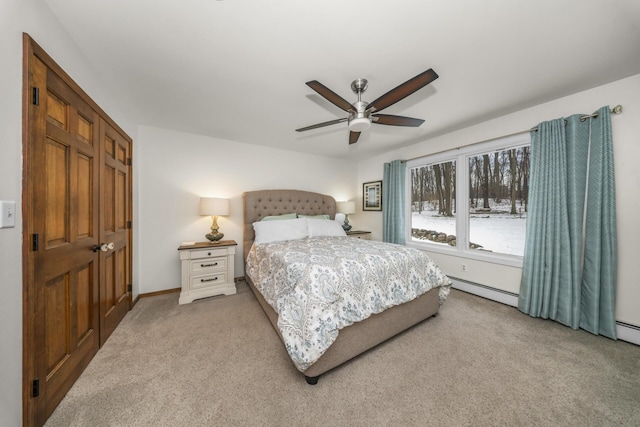 bedroom with a baseboard radiator, baseboards, a ceiling fan, and carpet