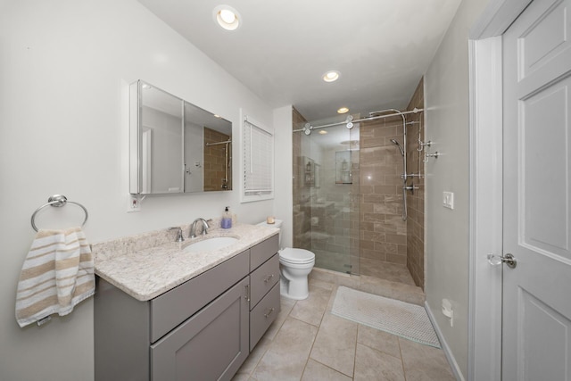 bathroom with tile patterned floors, toilet, a stall shower, recessed lighting, and vanity