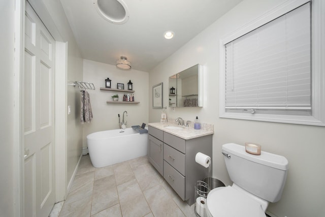 full bathroom with a soaking tub, tile patterned floors, toilet, baseboards, and vanity