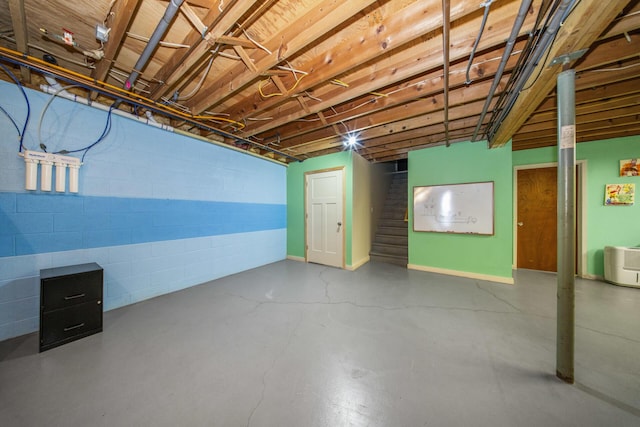 unfinished below grade area featuring stairs and concrete block wall