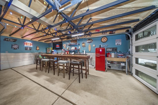 bar with concrete floors, a workshop area, and a dry bar