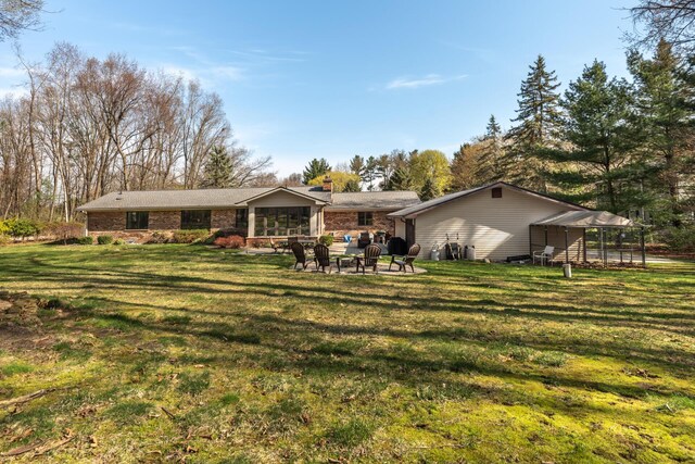 back of property with a lawn, an outdoor fire pit, and a chimney