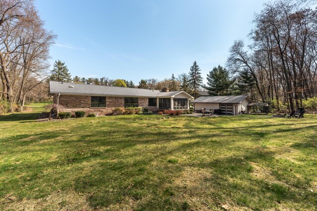 view of front of house featuring brick siding, a chimney, and a front lawn