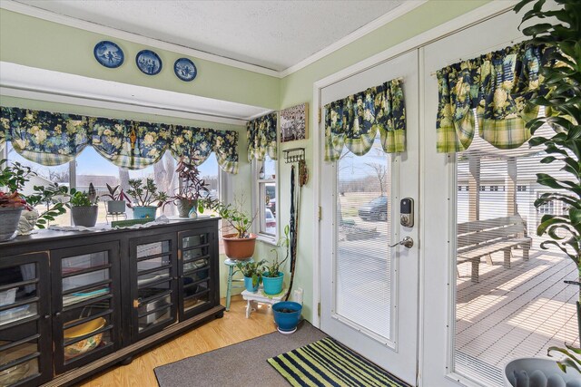 846 Morton Rd, Horton, MI 49246 - doorway to outside featuring a textured ceiling, crown molding, and wood finished floors
