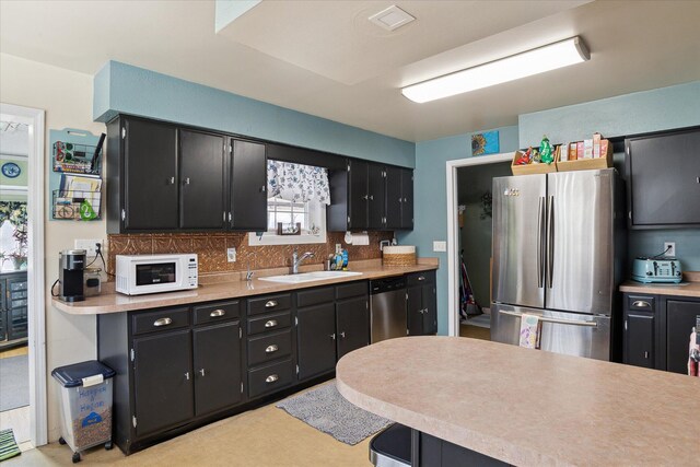 846 Morton Rd, Horton, MI 49246 - kitchen with a sink, tasteful backsplash, appliances with stainless steel finishes, and dark cabinetry
