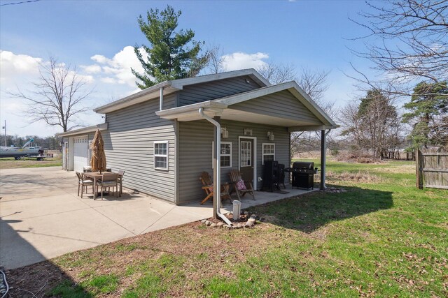846 Morton Rd, Horton, MI 49246 - back of property with a patio area, driveway, an attached garage, and a lawn