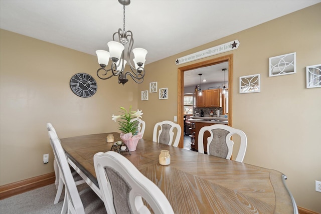 dining room with a notable chandelier and baseboards