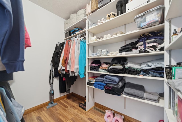 spacious closet featuring visible vents and wood finished floors