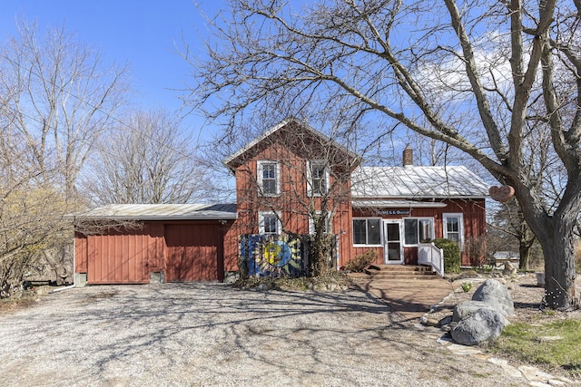 view of front of property featuring a chimney, entry steps, and metal roof