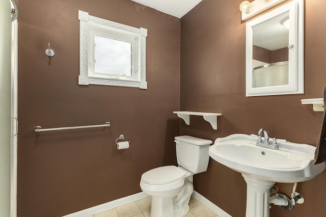 bathroom featuring toilet, tile patterned floors, and baseboards