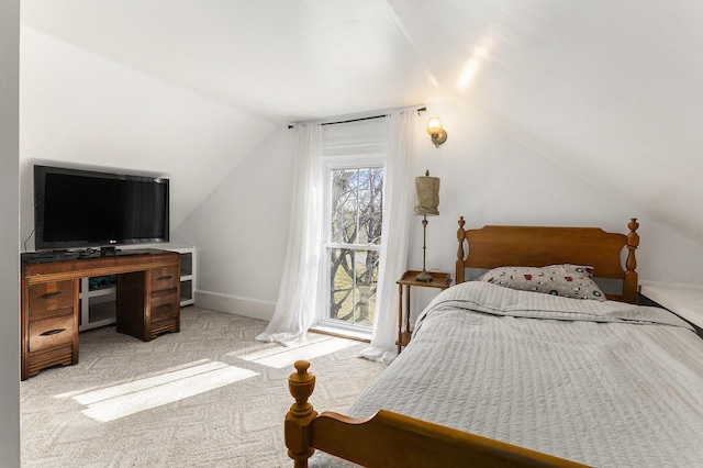 carpeted bedroom with lofted ceiling and baseboards