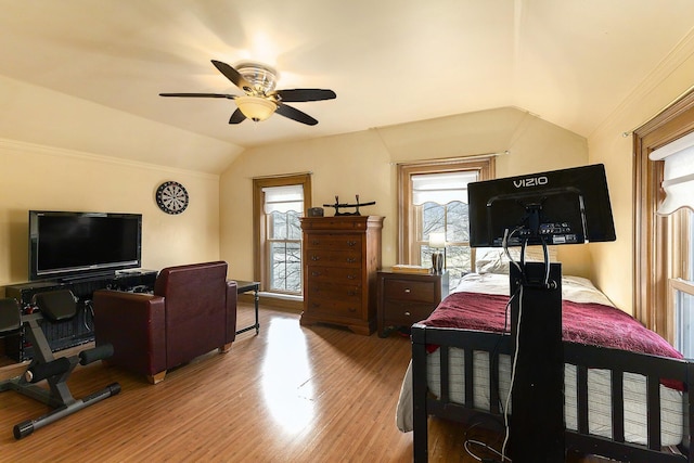 bedroom with vaulted ceiling, a ceiling fan, multiple windows, and light wood-type flooring