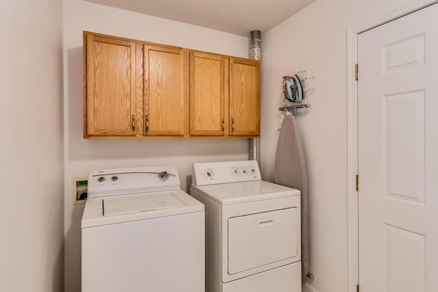 washroom featuring cabinet space and washer and clothes dryer