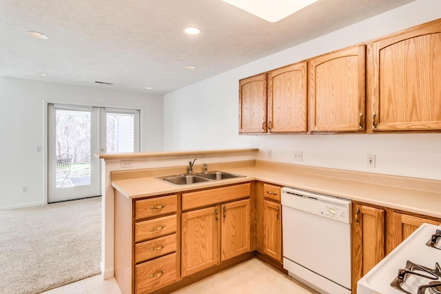 kitchen featuring white dishwasher, a sink, a peninsula, recessed lighting, and stove
