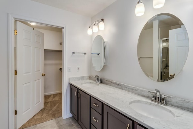 full bathroom featuring a shower with door, double vanity, and a sink