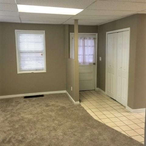 201 E Danaher St, Ludington, MI 49431 - empty room with visible vents, baseboards, a paneled ceiling, and light tile patterned flooring