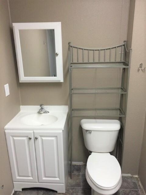 201 E Danaher St, Ludington, MI 49431 - bathroom with vanity, baseboards, and toilet
