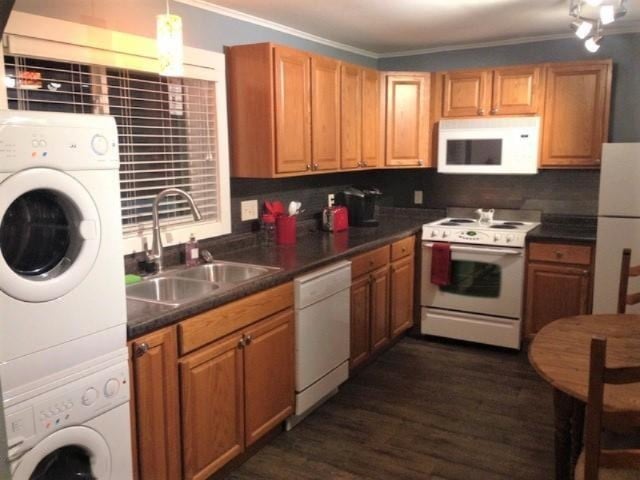 201 E Danaher St, Ludington, MI 49431 - kitchen with stacked washer and dryer, white appliances, crown molding, dark countertops, and a sink