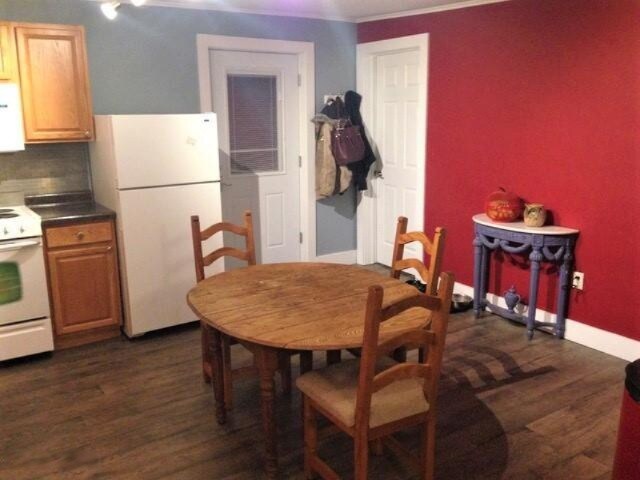 201 E Danaher St, Ludington, MI 49431 - dining space with ornamental molding, baseboards, and dark wood finished floors