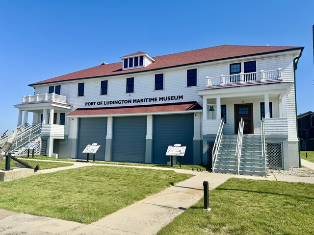 201 E Danaher St, Ludington, MI 49431 - view of front of property with a porch, an attached garage, a front yard, and stairs