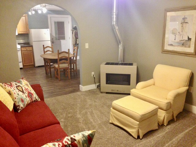 201 E Danaher St, Ludington, MI 49431 - living area with arched walkways, carpet floors, baseboards, and heating unit