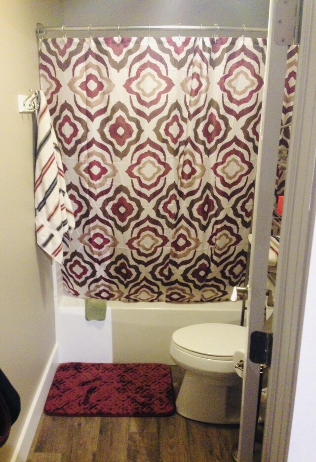201 E Danaher St, Ludington, MI 49431 - full bathroom with shower / bath combo, toilet, and wood finished floors