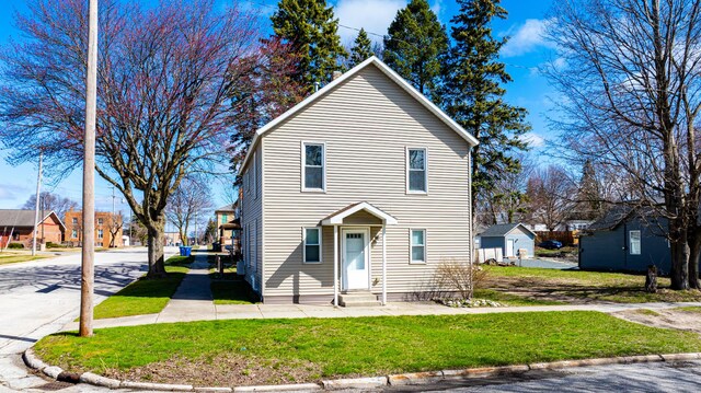 201 E Danaher St, Ludington, MI 49431 - traditional-style home with entry steps, a front yard, and a residential view