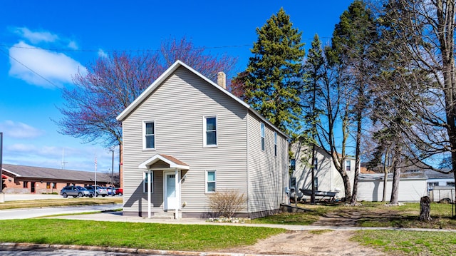 201 E Danaher St, Ludington, MI 49431 - traditional-style home featuring a front lawn and a chimney