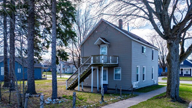 201 E Danaher St, Ludington, MI 49431 - traditional home with a chimney, a front lawn, and stairway