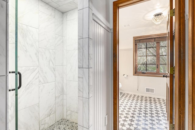 10159 E Rivershore Dr SE, Alto, MI 49302 - bathroom with tile patterned floors, a wainscoted wall, toilet, a shower stall, and visible vents
