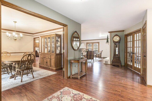 10159 E Rivershore Dr SE, Alto, MI 49302 - dining room with baseboards, an inviting chandelier, french doors, crown molding, and wood finished floors