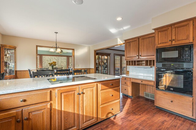 10159 E Rivershore Dr SE, Alto, MI 49302 - kitchen featuring brown cabinetry, wainscoting, black appliances, and hanging light fixtures