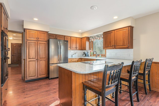 10159 E Rivershore Dr SE, Alto, MI 49302 - kitchen with a sink, light countertops, black appliances, and a peninsula