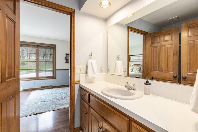 10159 E Rivershore Dr SE, Alto, MI 49302 - ensuite bathroom with visible vents, ensuite bath, wood finished floors, and vanity