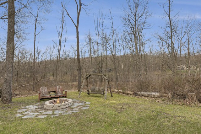 10159 E Rivershore Dr SE, Alto, MI 49302 - view of yard with an outdoor fire pit and a view of trees